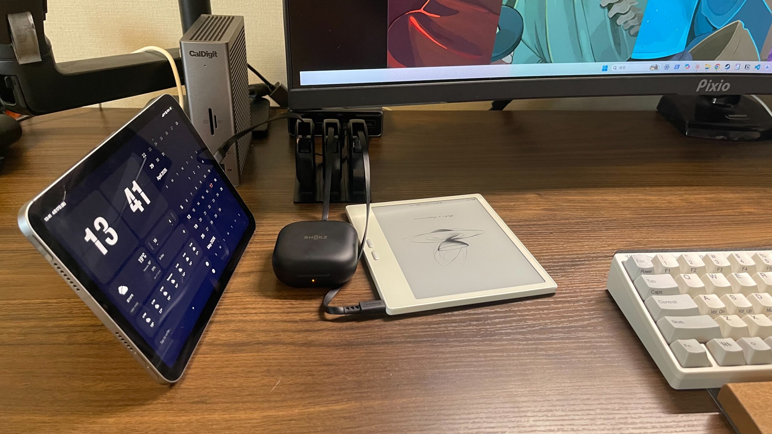 巻取り式コード３つを使ってipadとイヤホンとe-inkタブレットを充電している様子（引きの絵）